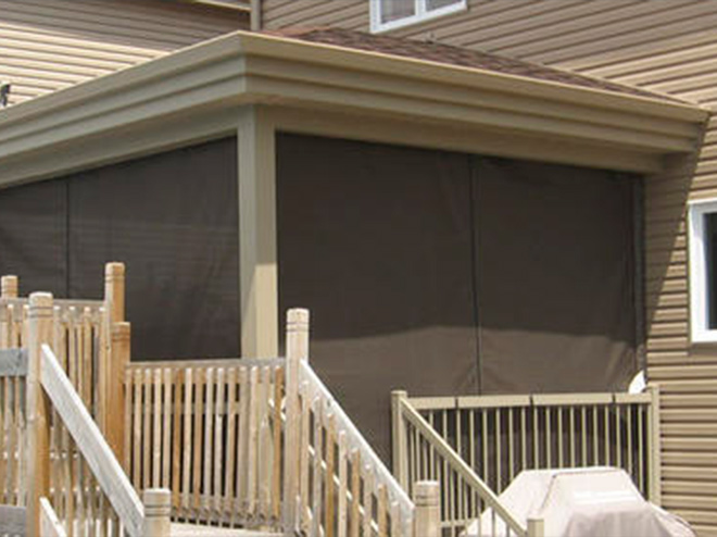 Balcon de maison ayant des rideaux d'intimités bruns sur chaque côté